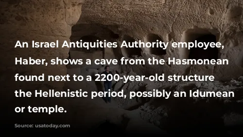 An Israel Antiquities Authority employee, Michal Haber, shows a cave from the Hasmonean period found next to a 2200-year-old structure from the Hellenistic period, possibly an Idumean palace or temple.