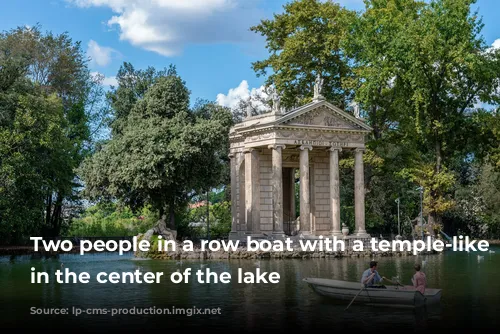 Two people in a row boat with a temple-like building in the center of the lake