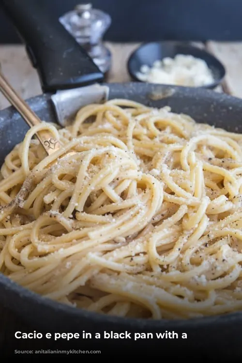 Cacio e pepe in a black pan with a fork.