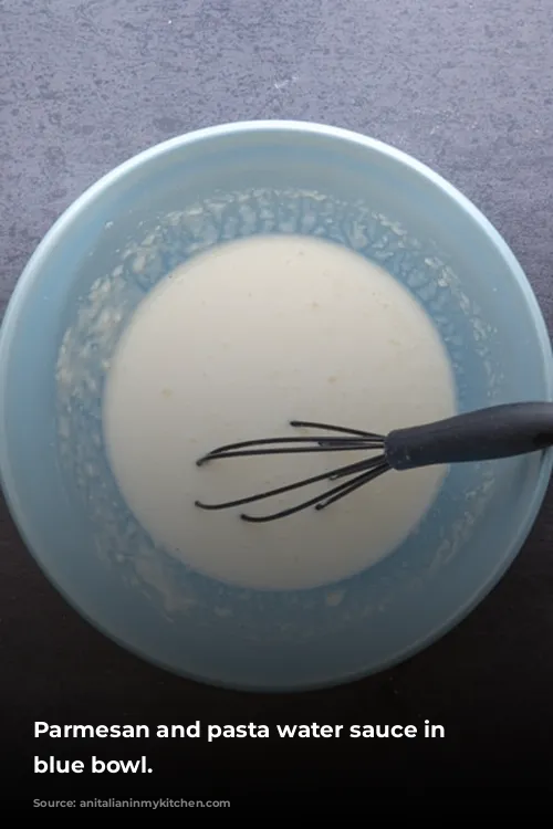 Parmesan and pasta water sauce in a blue bowl.