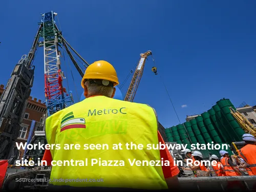 Workers are seen at the subway station construction site in central Piazza Venezia in Rome, Italy