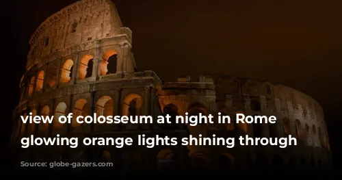 view of colosseum at night in Rome with glowing orange lights shining through windows